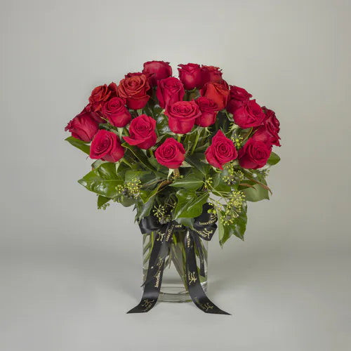 Temptation Deluxe 24 Red Roses in a Vase  Interflora’s Temptation Deluxe will wow your recipient. 24 red roses with foliage in a vase is the perfect gift to surprise your loved one. 