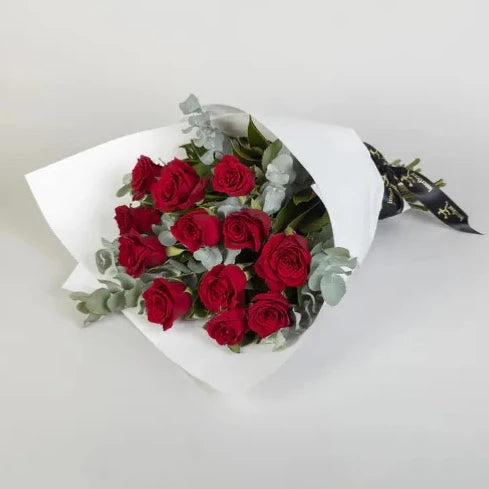12 Red Rose Bouquet  Surprise them with this bouquet of 12 fresh red roses for any romantic occasion. Expertly nestled amongst lush green foliage and perfectly wrapped and tied with ribbon, your loved one will adore these romantic flowers.